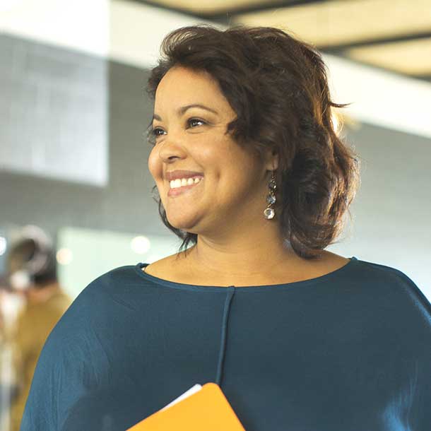 A public sector treasury professional smiling while holding a folder of documents